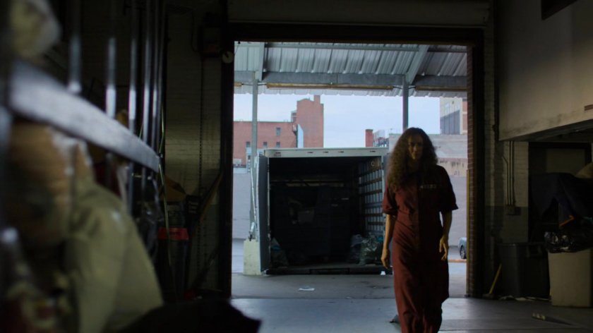 Alisa entering a warehouse from a loading dock.
