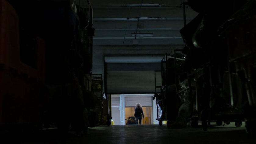 Alisa leaving a warehouse.