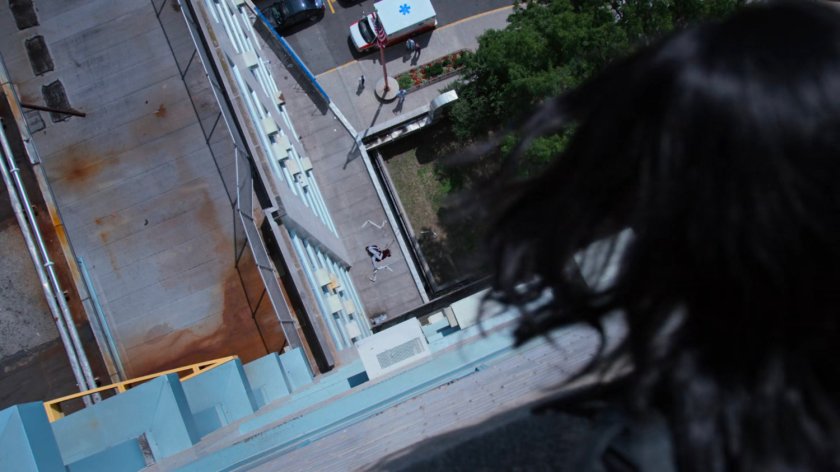 Jessica looking at a dead Detective Sunday on the roof of Riverbank Medical Center.