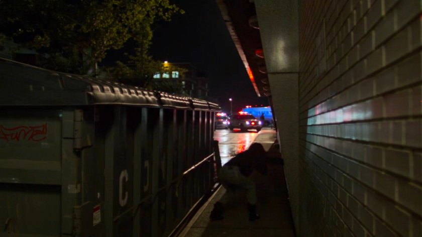 Jessica behind a trash dumpster outside Riverbank Medical Center.