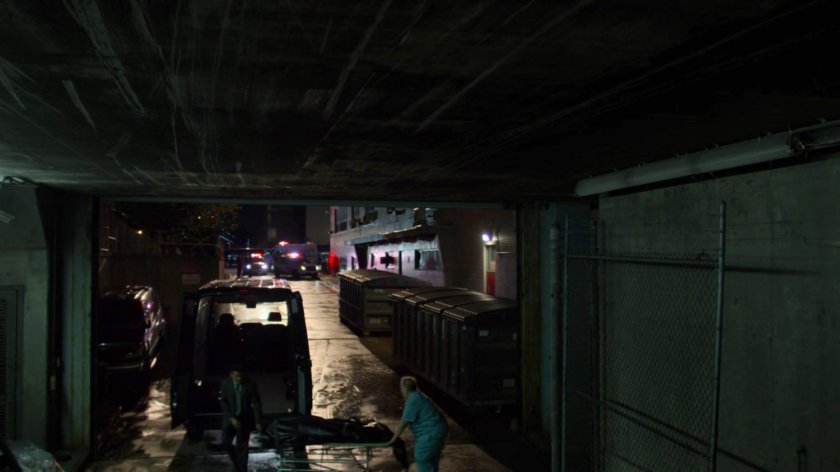 Men loading bodies in a mortuary van outside Riverbank Medical Center.