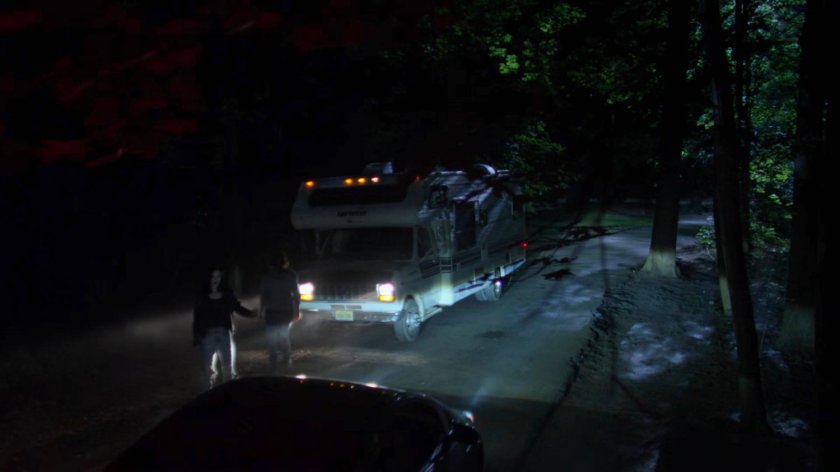 Jessica and Alisa on a dark road lit by RV headlights.