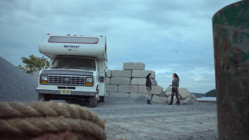 Alisa and Jessica outside an RV at a gravel quarry.
