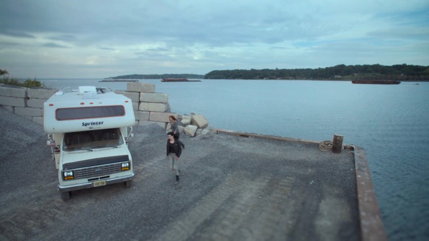 Alisa and Jessica outside an RV at a gravel quarry.