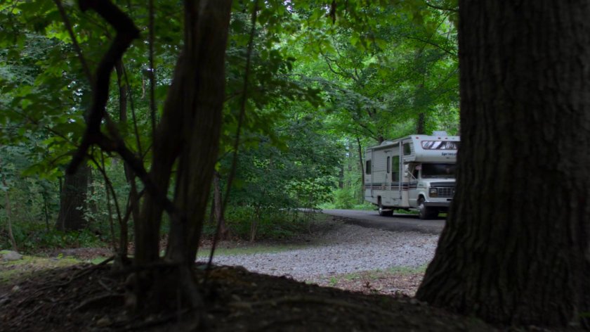 An RV driving on a wooded Westchester road.