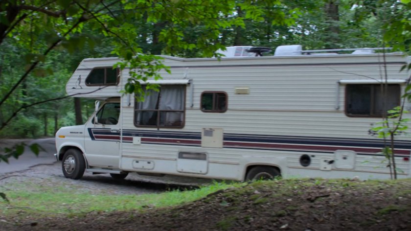 An RV driving on a wooded Westchester road.