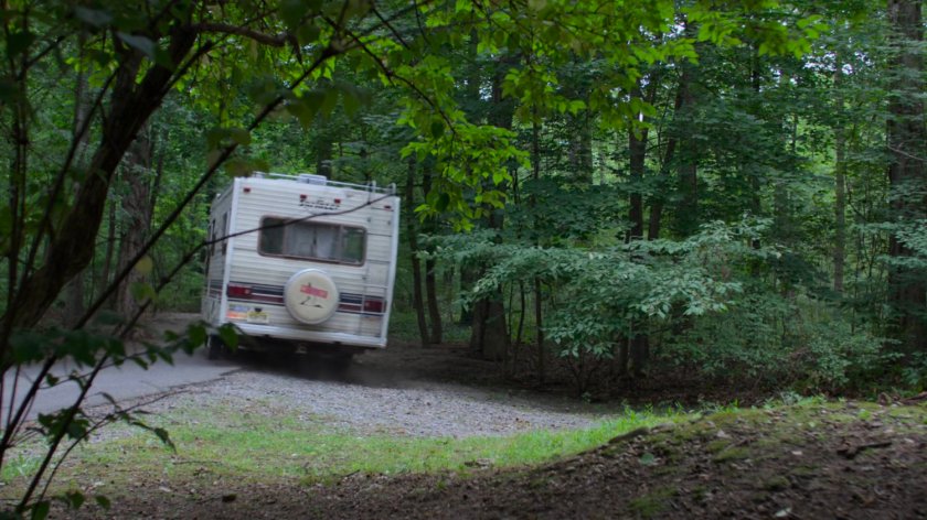An RV driving on a wooded Westchester road.