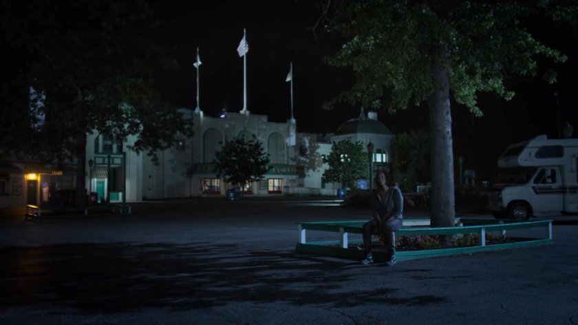 Alisa sitting outside Playland amusement park at night.