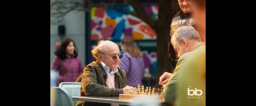 BB Report: two men playing chess while an AVTF agent looks on.