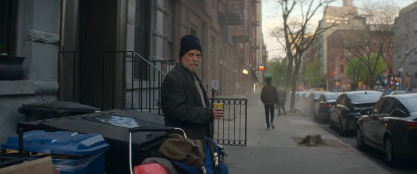 A man standing on the sidewalk outside Dex's apartment building.