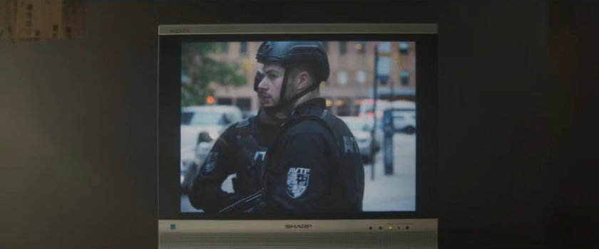 Television showing a news report on the boxing match at Fogwell's Gym, with two AVTF officers outside.