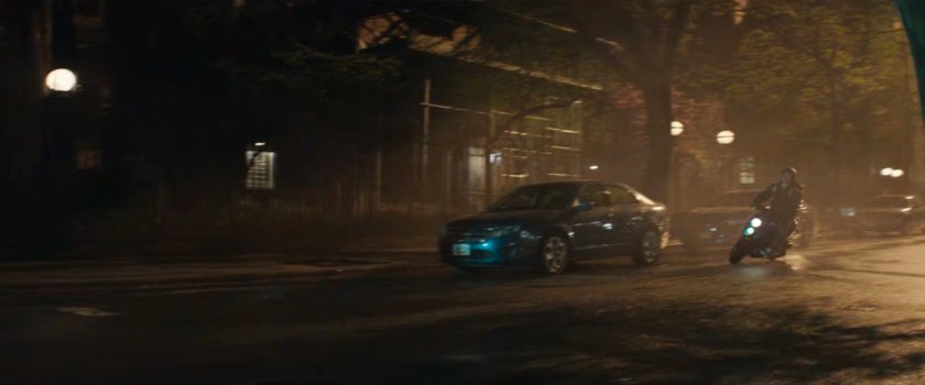 A motorcycle driving past Dex's apartment building.