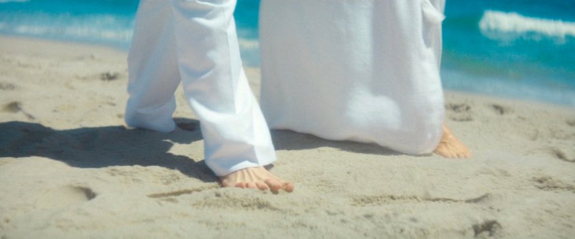 Fisk and Vanessa walking along the beach on their island.