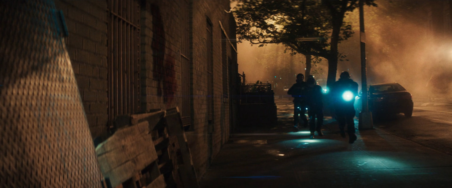 AVTF Officers running along the sidewalk at night.