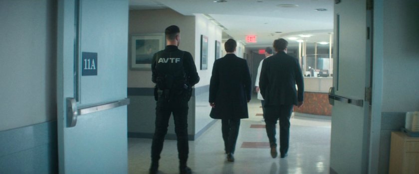 Daniel, Buck, and an AVTF Officer in the hallway of Metro-General.