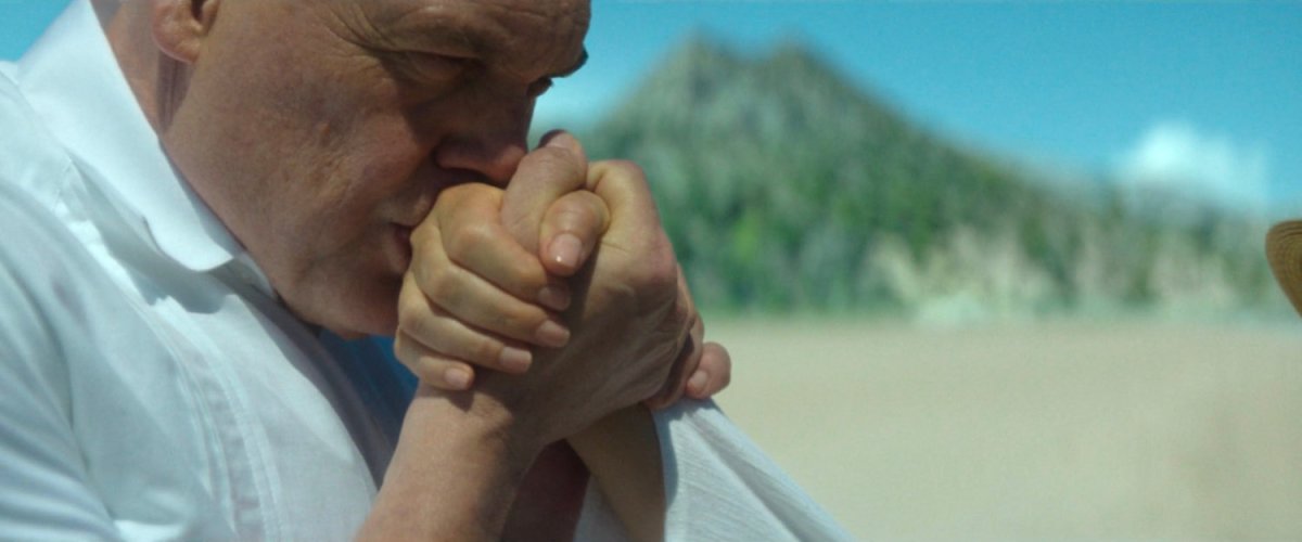 Fisk kissing Vanessa's hand along the beach on their island.