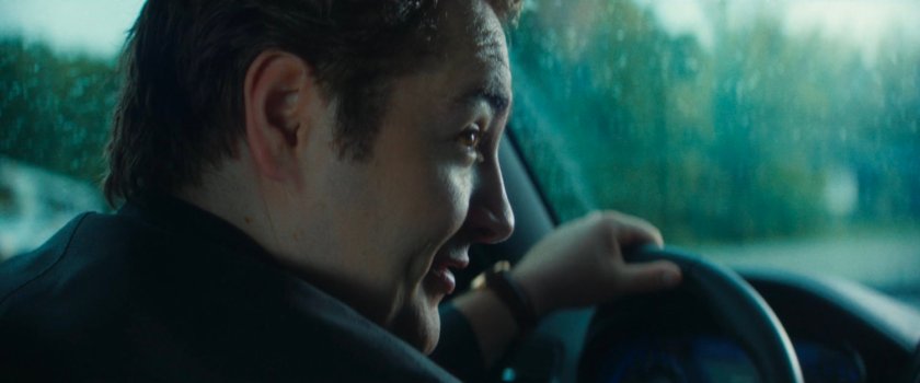 Daniel driving his car along a highway.