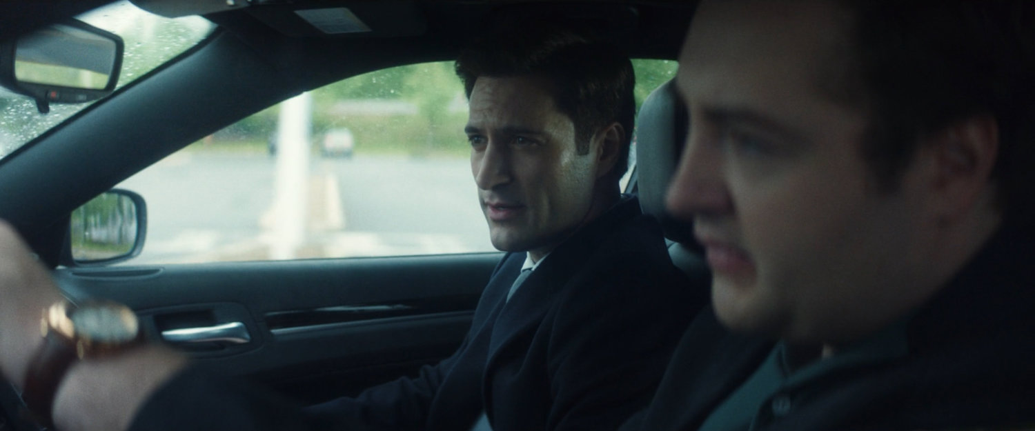 Daniel driving his car, with Buck, along a highway.