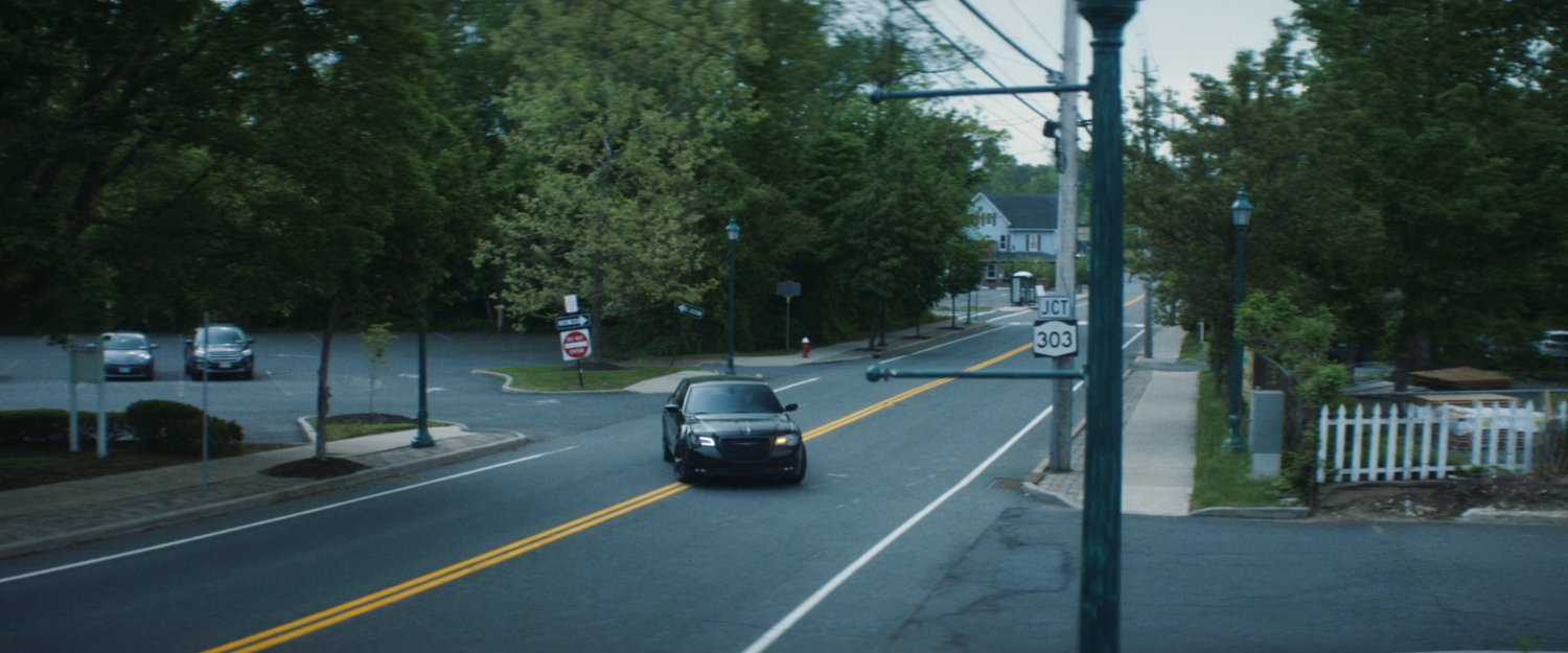 Daniel's car pulling into a lumber store parking lot.