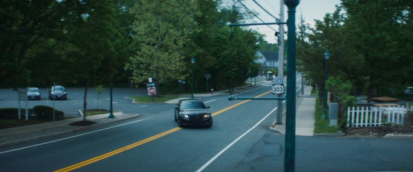 Daniel's car pulling into a lumber store parking lot.