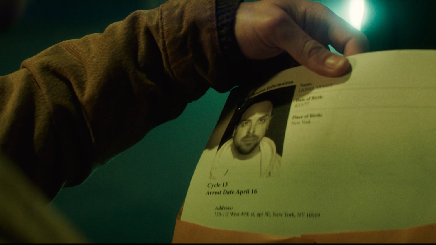 Buck holding a printout of Lionel McCoy's home address.