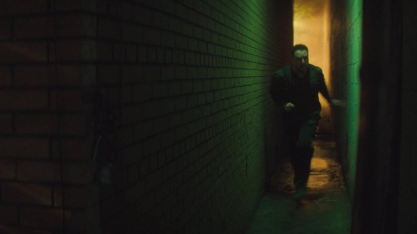 Flashback of Lionel running through an alley outside his apartment building.