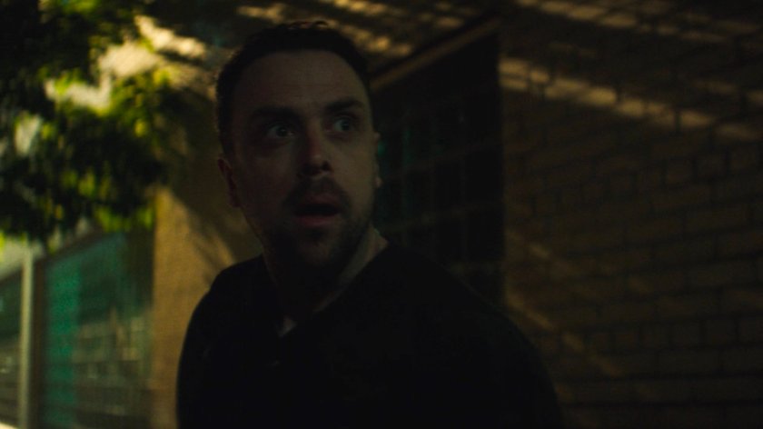 Flashback of Lionel running on the sidewalk outside his apartment building.