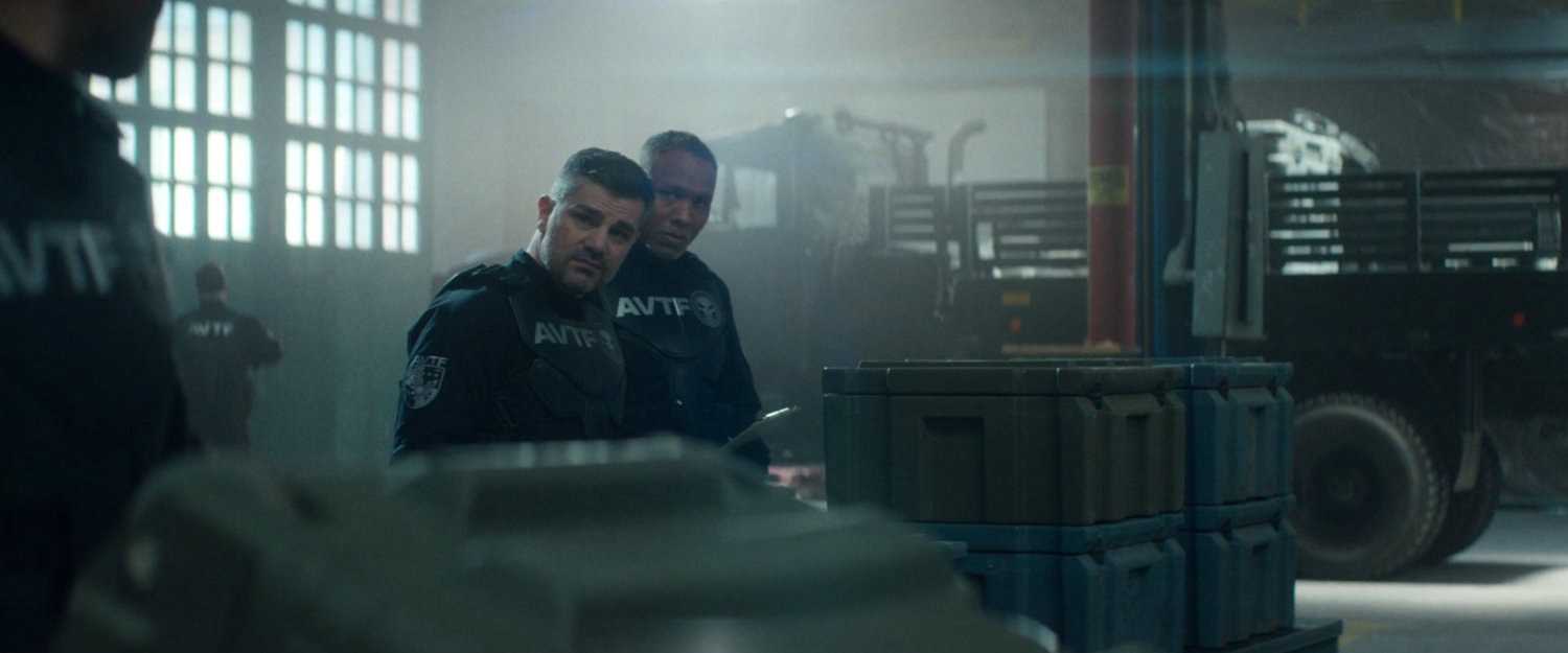 AVTF agents Powell and Cole inside a weapons storage warehouse.