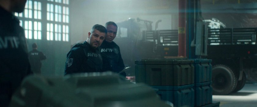 AVTF agents Powell and Cole inside a weapons storage warehouse.
