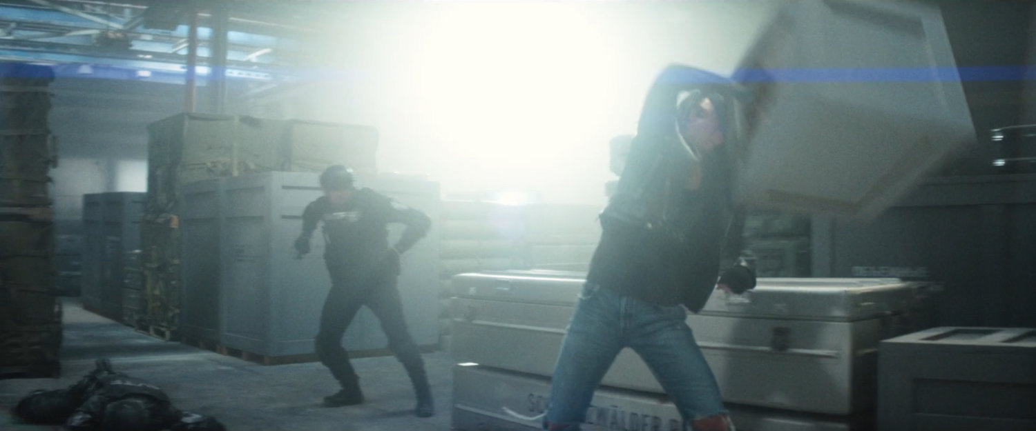 Jessica fighting an AVTF officer in a weapons storage warehouse.