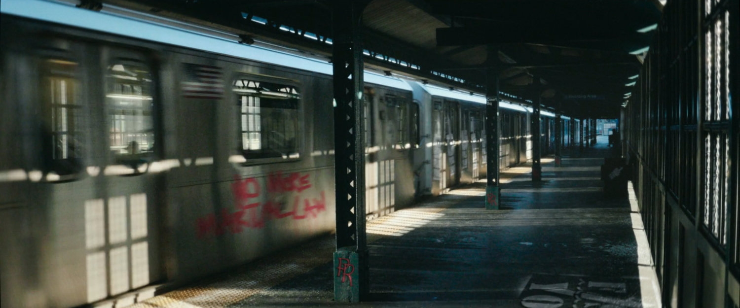 Interstitial: Subway station with train speeding past.