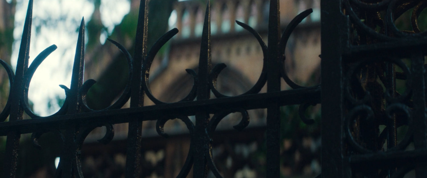 Interstitial: wrought iron gate outside a church.
