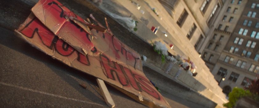 Trampled flowers and signs outside City Hall.