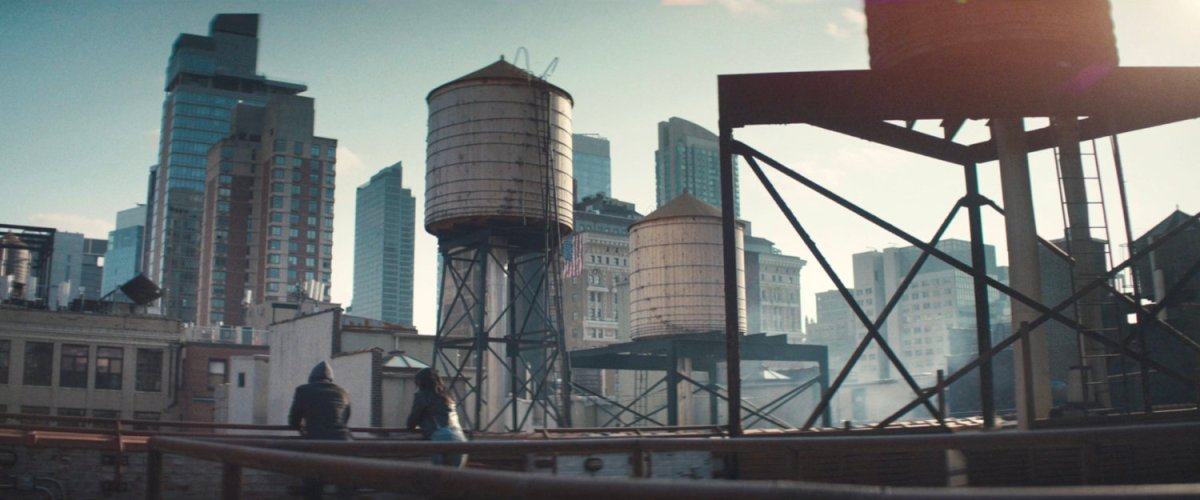 Matt and Jessica discuss next steps on a city rooftop.