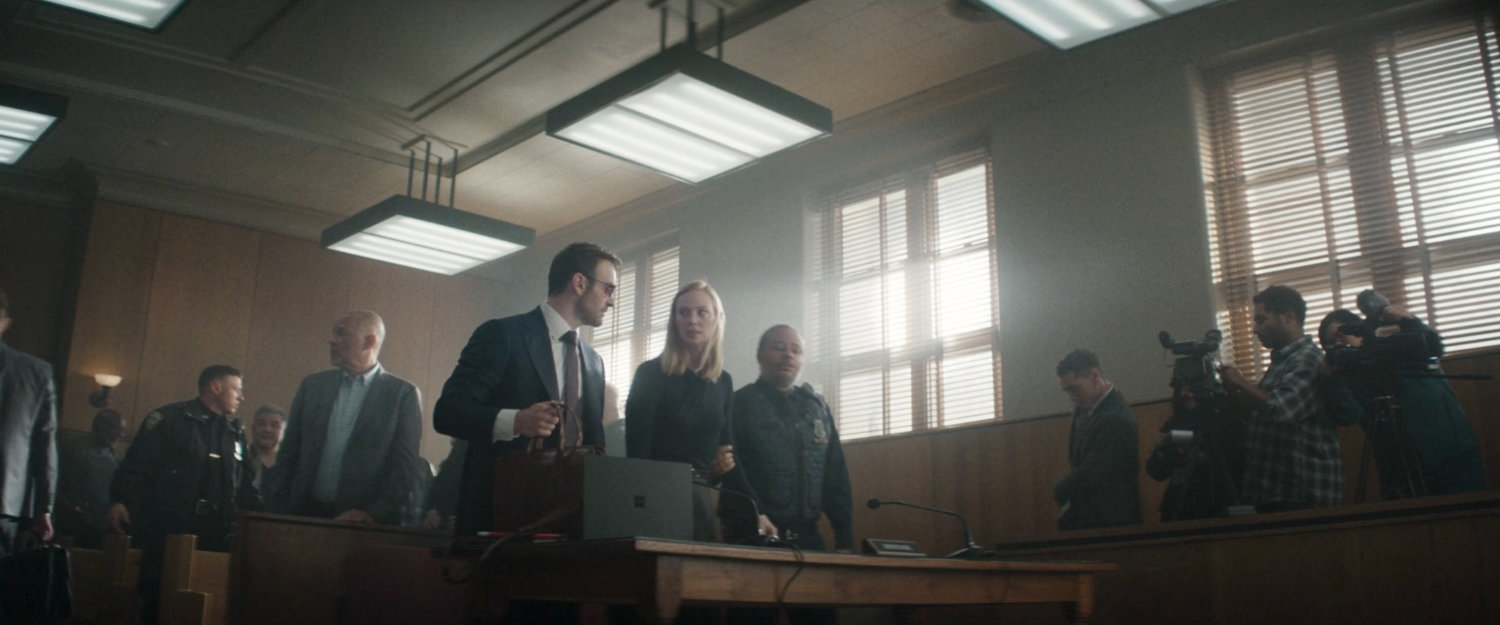 Matt and Karen in a crowded city courtroom.