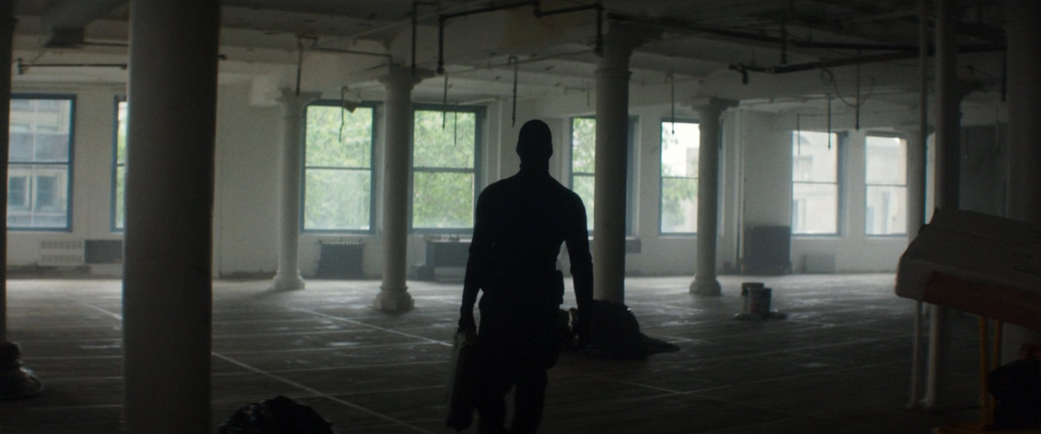 A man walking through an empty office in a building across the street from the city courthouse.
