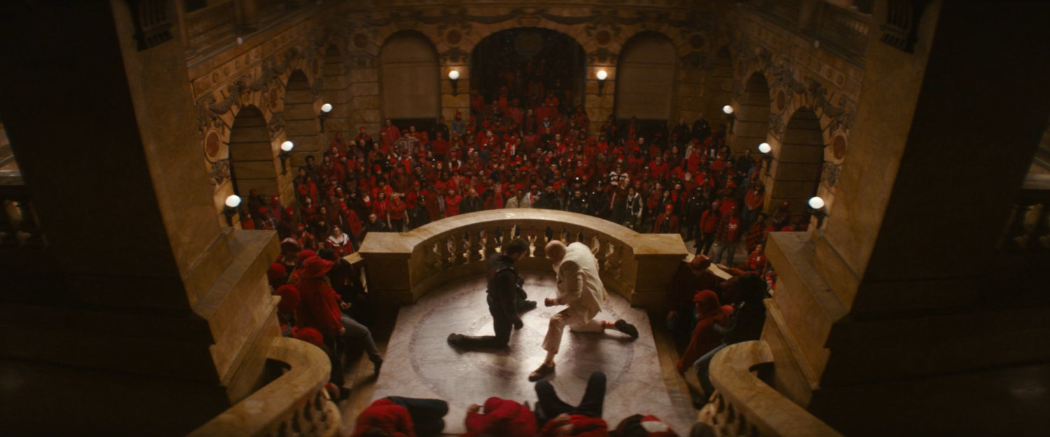 Daredevil and Fisk amongst a crowd of citizens in the city courthouse lobby.