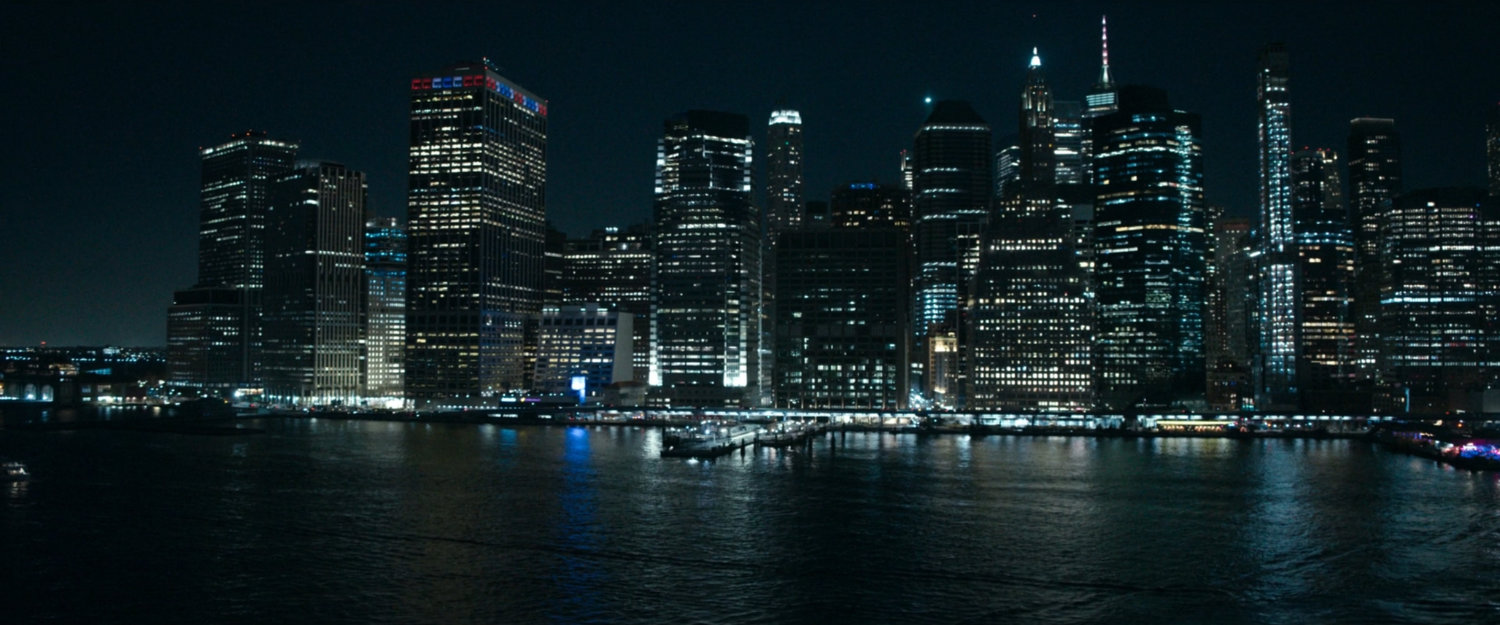 Manhattan at night as seen over the water.