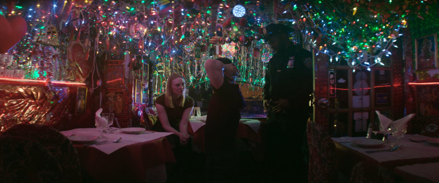 Karen, Matt, and a police officer inside Panna II Restaurant.