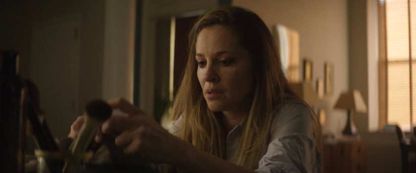 Heather looking at Muse's mask in her office.