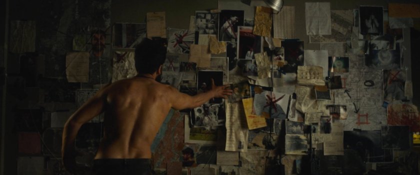 Frank tearing down his photos in his apartment.