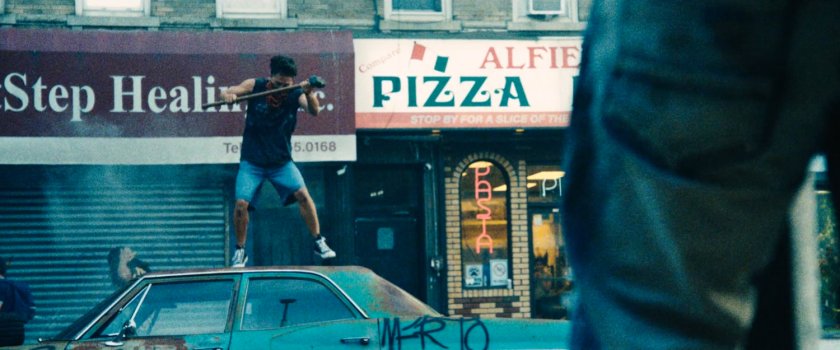Rioters attack a car outside a pizza restaurant in Little Sicily.