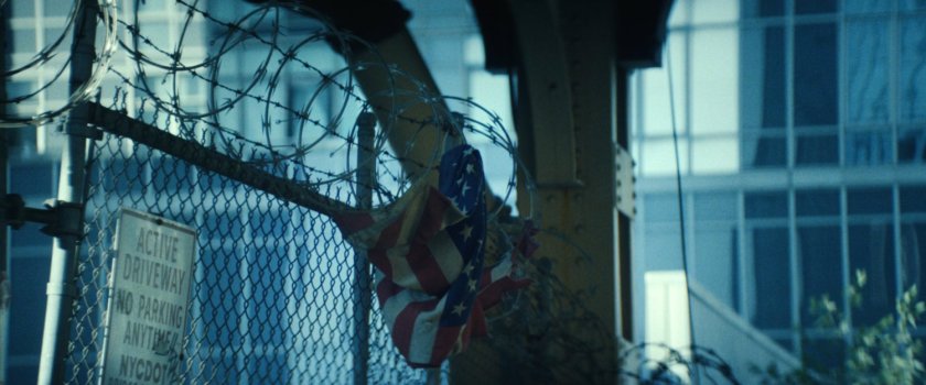 A crumpled American flag stuck in barbed wire in Little Sicily.