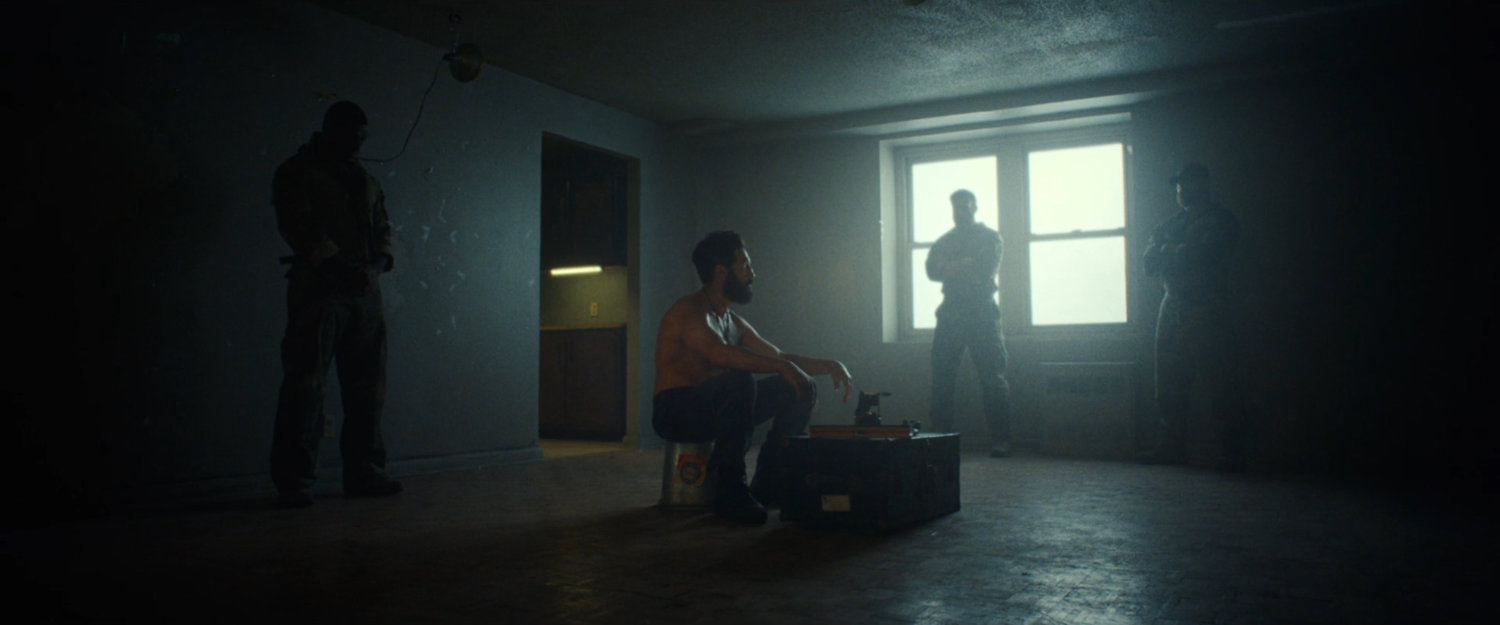 Frank surrounded by the ghosts of his buddies in his apartment.