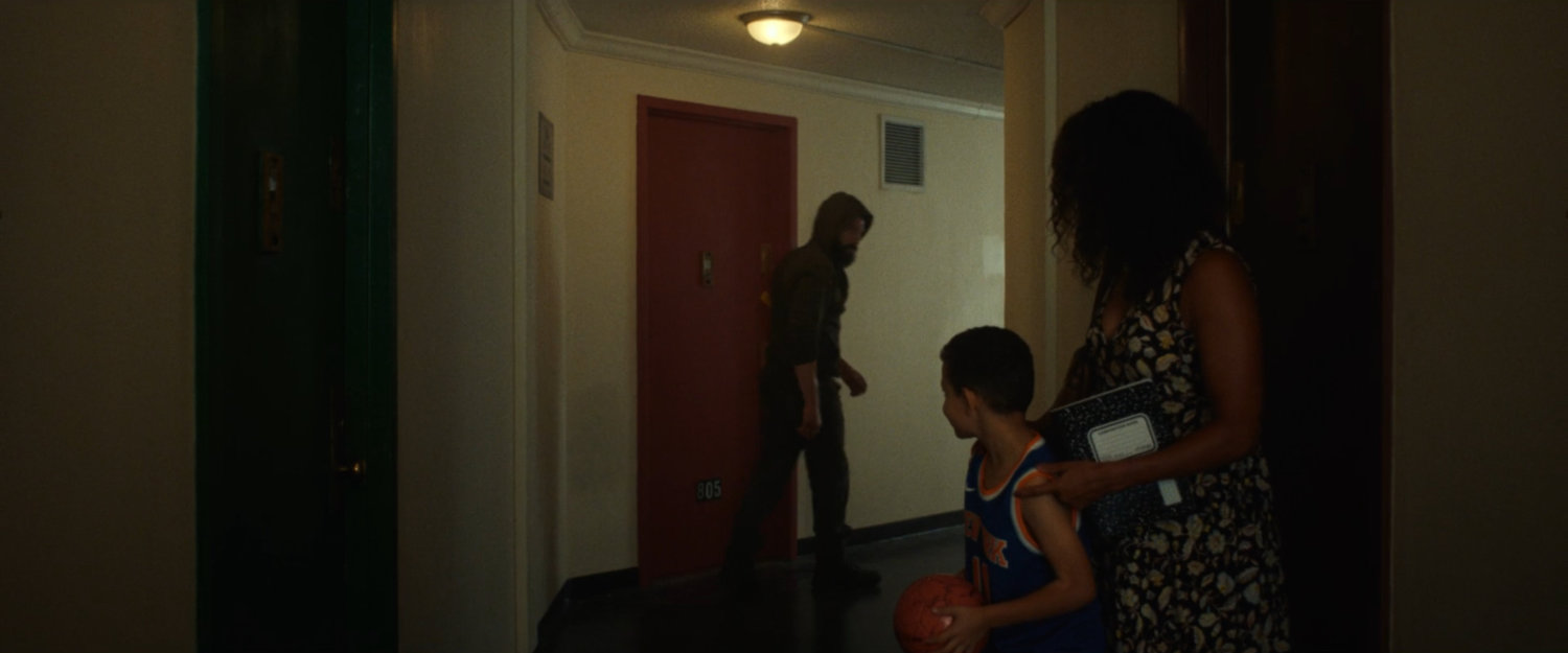 Frank leaving his apartment, walking past Isaiah and his mom.