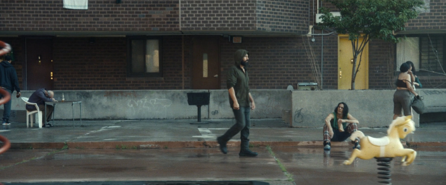 Frank walking across the quad in front of his apartment building.
