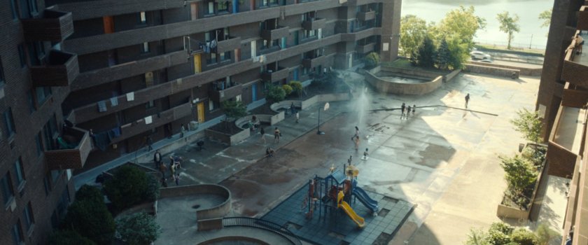 High angle view of Frank walking across the quad in front of his apartment building.
