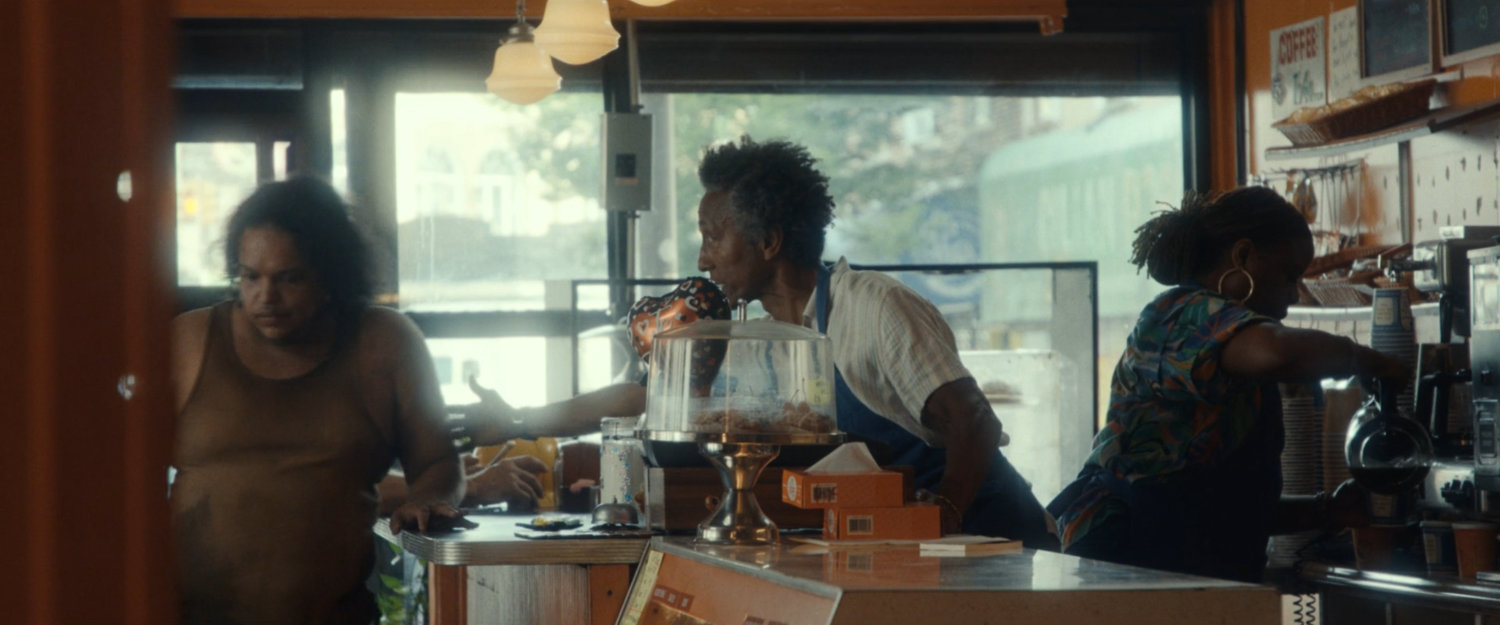 Dre and a customer inside his Donut shop.