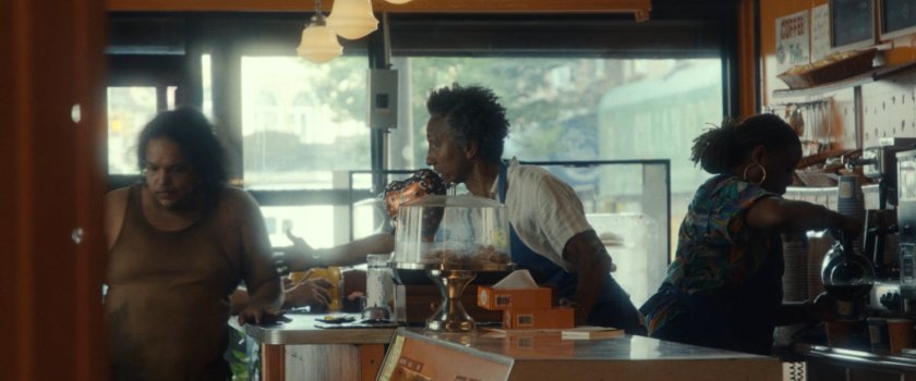 Dre and a customer inside his Donut shop.