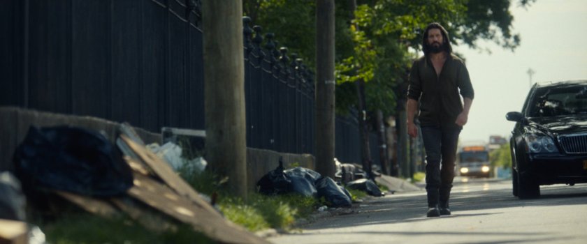 Frank walks along a road outside a cemetery.